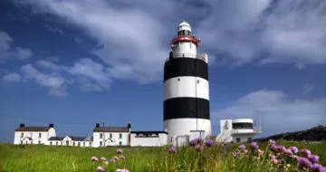 Children waving with Hook Lighthouse in the background